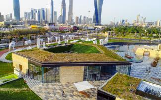 Building with a green roof amidst a green park in the city